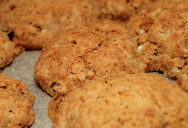 Kağıt kaplı fırın tepsisindeki süzme peynir ve un kurabiyeleri.