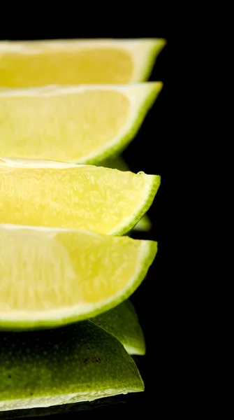 Limes on black mirror — Stock Photo, Image