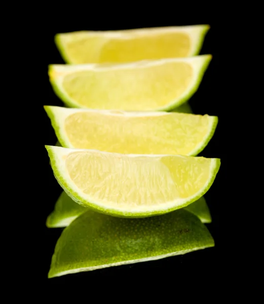 Limes on black mirror — Stock Photo, Image