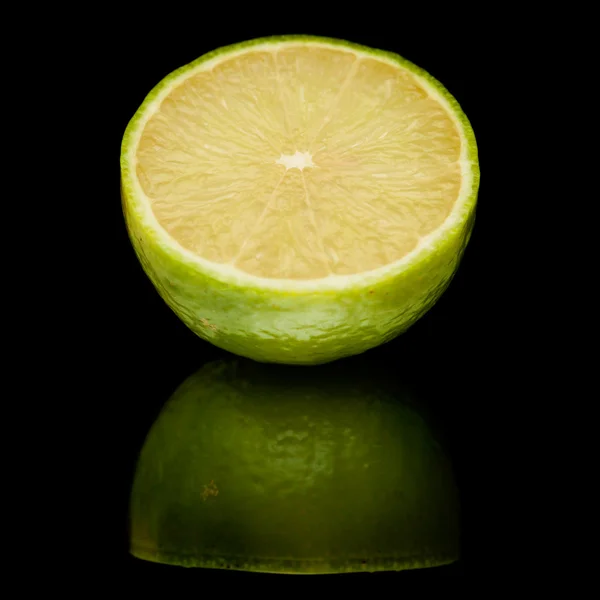 Limes auf schwarzem Spiegel — Stockfoto