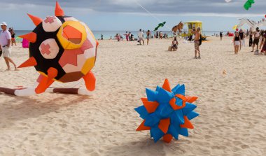 Fuerteventura, İspanya - 16 Kasım 2025: İzleyiciler Corralejo 'nun Doğa Parkı Kumulları' ndaki Uluslararası Uçurtma Festivali 'nde çok renkli uçurtmaların keyfini çıkarıyorlar