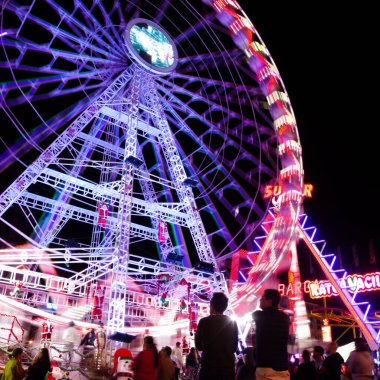Las Palmas de Gran Canaria, İspanya - 08 Aralık 2025: Ziyaretçiler, Noel dönemi için Santa Catalina parkına yakın bir yere kurulmuş, gece aydınlığında bir lunaparkın keyfini çıkarıyorlar