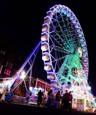 Las Palmas de Gran Canaria, İspanya - 08 Aralık 2025: Ziyaretçiler, Noel dönemi için Santa Catalina parkına yakın bir yere kurulmuş, gece aydınlığında bir lunaparkın keyfini çıkarıyorlar