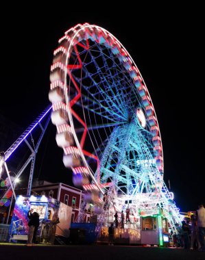Las Palmas de Gran Canaria, İspanya - 08 Aralık 2025: Ziyaretçiler, Noel dönemi için Santa Catalina parkına yakın bir yere kurulmuş, gece aydınlığında bir lunaparkın keyfini çıkarıyorlar