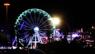 Las Palmas de Gran Canaria, İspanya - 08 Aralık 2025: Ziyaretçiler, Noel dönemi için Santa Catalina parkına yakın bir yere kurulmuş, gece aydınlığında bir lunaparkın keyfini çıkarıyorlar