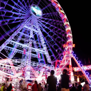 Las Palmas de Gran Canaria, İspanya - 08 Aralık 2025: Ziyaretçiler, Noel dönemi için Santa Catalina parkına yakın bir yere kurulmuş, gece aydınlığında bir lunaparkın keyfini çıkarıyorlar