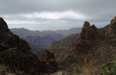 Gran Canaria, adanın merkezi manzarası, Las Cumbres, ie The Summits, Ventana del Bentayga adındaki bir kaya kemerine yürüyüş rotası, Bentayga penceresi, dağların üzerinden yağmur geliyor.