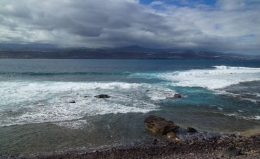 Gran Canaria, Las Palmas de Gran Kanarya 'nın kıyısındaki El Confital plajından adanın ana gövdesine doğru yağmur adaya yayılıyor.