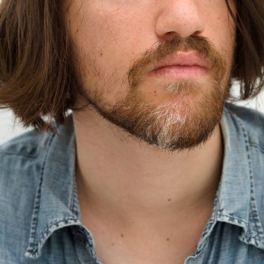 Kısmen gri sakallı yirmili yaşlarının ortasında genç bir adam.