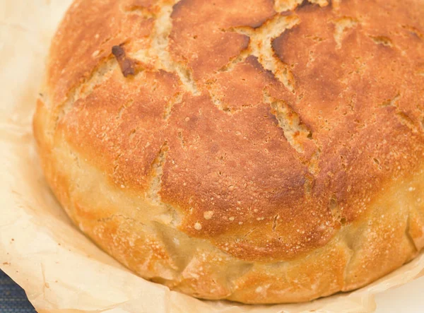 Bir parça parşömenin içinde taze pişmiş mayalı ekmek.