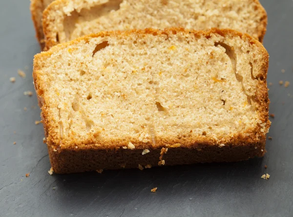 Gâteau orange tranché sur un plateau en ardoise — Photo