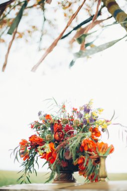 metal bir çim zemin üzerine açık havada göğsünde bir bronz vazo içinde güzel vahşi kırmızı çiçekler vardır