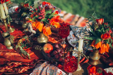 Candels ve çiçekler. Boho dekoru sofra. Güzel Sanatlar tarzında yapılmış fotoğraf. Film fotoğraf gibi stilize