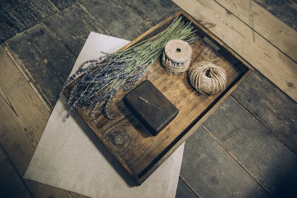 Красивая стильная деревянная коробка, лежащая на тканях из хлопка на деревянном подносе — стоковое фото