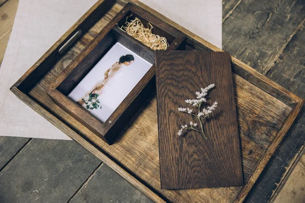 Wooden box for photos with a photograph lying on a wooden tray beautiful stylized stylish fine art under the film with beautiful photography — Stok fotoğraf