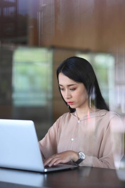 İş kadını portresi dizüstü bilgisayarını kullanarak yeni proje fikri üzerinde çalışıyor..
