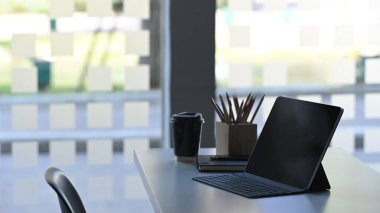 Modern ofisteki rahat çalışma masasında dizüstü bilgisayar ve ofis ekipmanıyla iş yerinin yan görüntüsü..