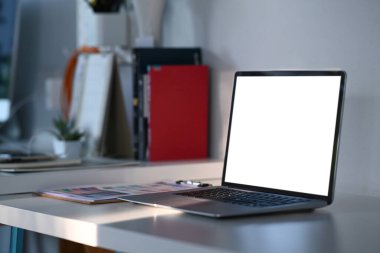 Grafik tasarımcısı veya tasarımcı çalışma alanı üzerine beyaz ekran kullanan dizüstü bilgisayarın yan görünümü.