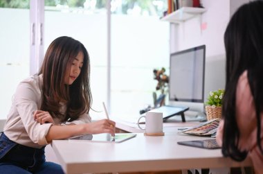 Modern ofiste çalışan ve yeni bir proje planlayan iki genç yaratıcı kadın..