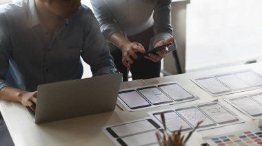UxUi geliştirme ekibinin modern toplantı masasındaki projeleri tartışırken çekilmiş görüntüleri. Beyin Fırtınası / Toplantı / İş Projesi kavramı.