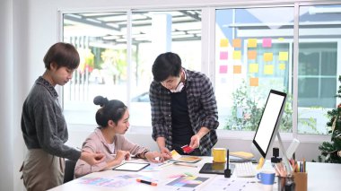 Yaratıcı tasarımcılardan oluşan bir ekip modern konferans odasında proje hakkındaki fikirleri paylaşıyor.. 