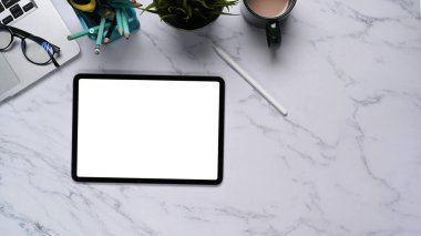 Dijital tablet, dizüstü bilgisayar ve kahve fincanının mermer desenli olduğu düz bir çalışma alanı fotoğrafı..