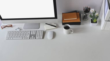 Üst görünüm çalışma alanı. Fotokopi bilgisayarı, kahve, kaktüs ve ofis malzemeleri beyaz masada..