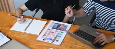 İş yerinde renk örnekleri üzerinde çalışan iki yaratıcı grafik tasarımcısının görüntüsü..