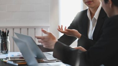İş idarecileri iş planlarını tartışıyor / konuşuyor / görüşüyorlar. Bu sırada modern toplantı masasında rahat bir ofis arka planında oturuyorlar..