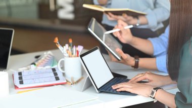 Yakın plan genç grafik tasarımcı takımı onlar hakkında planlama / toplantı / tartışma Modern toplantı masasında iş büyüme kılavuzları bilgisayar tableti ve not defteri ile. Ofis konseptinde işbirliği.