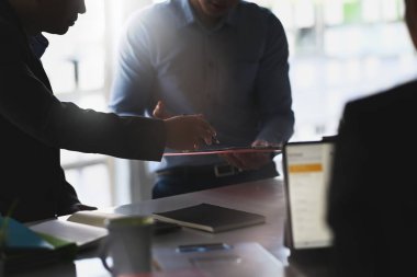 İş adamları modern ofis binasında beyin fırtınası yapıyor ve iş planlarını tartışıyorlar.