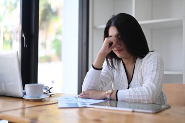 Genç Asyalı girişimci burnunu tutuyor yorgun ve bunalımda..