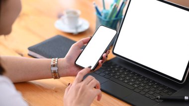 Tablet bilgisayarla çalışırken cep telefonu kullanan genç bayanı kapat.