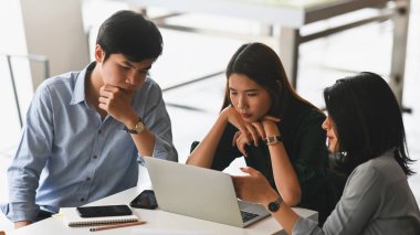 Geliştirme ekibi, arka plan olarak toplantı odası olan modern toplantı masasında otururken / ayakta kalırken / onlar hakkında tartışırken / konuşurken / konuşurken / toplantı yaparken yeni iş projeleri hakkında.