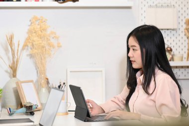 Genç bayan girişimci modern işyerindeki tablet bilgisayarda çalışıyor..