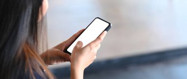 Sosyal ağlarda arkadaşlarıyla akıllı telefon konuşmaları yapan genç bir kadının yakın görüntüsü.