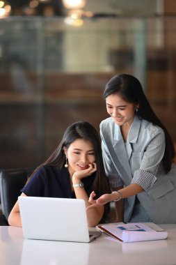 Arkadaş canlısı bir çalışan, iş arkadaşıyla konuşuyor. Ofiste fikir alışverişinde bulunuyor..