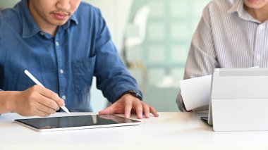 Meslektaşımla görüşürken bilgisayar tabletine yazan bir işadamı.