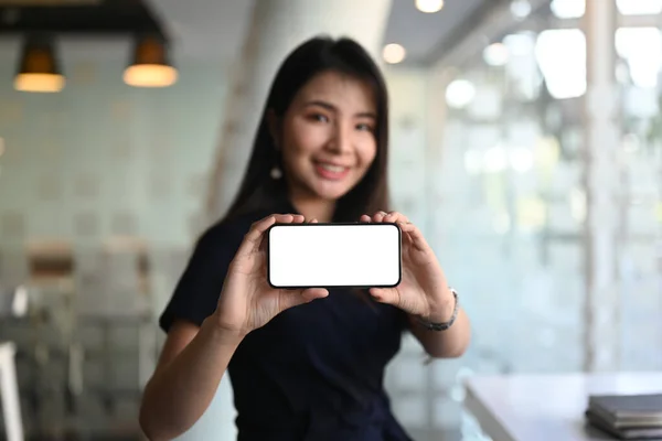 Businesswoman hands holding and showing horizontal smart phone with blank white screen. Blank screen for graphics display montage.