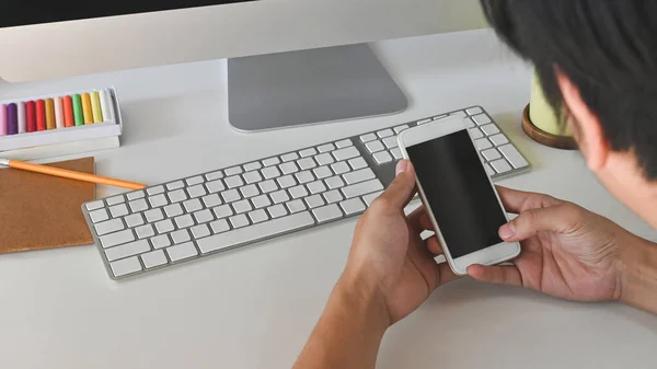 黒の空白の画面スマートフォンを保持しながら 現代の作業机と手の作物のショット — ストック写真