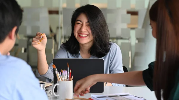 Business development team discussing/brainstorming/talking/meeting about them new project while sitting/standing at the modern meeting table with comfortable office as background.