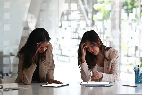 Two businesswomen or office workers are stressed and confused about their work.