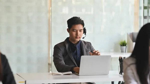 Zdjęcie Młodego Inteligentnego Operatora Słuchawkami Podczas Pracy Call Center Otoczeniu — Zdjęcie stockowe