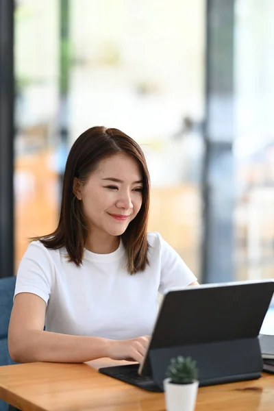 快適な職場に座っている間 タブレットコンピュータ上で働く幸せな若い女性のフリーランスの肖像画 — ストック写真