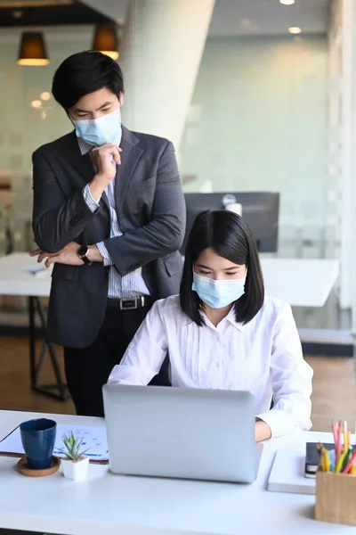 Businesspeople Protective Mask Analyzing Financial Figures Denoting Progress Laptop Modern — Stock Photo, Image