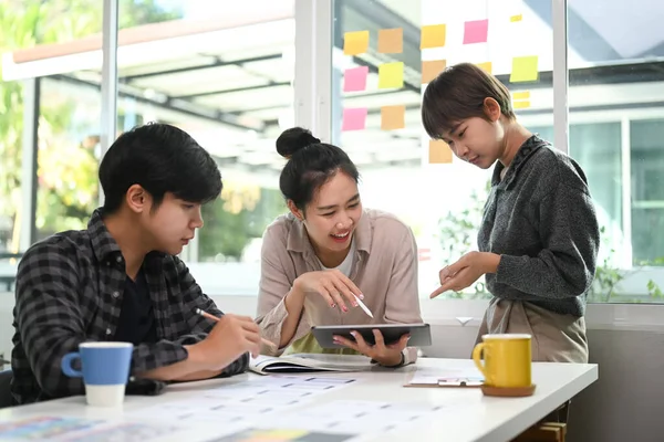 Group of creative designer people discussing new project plan in modern office.