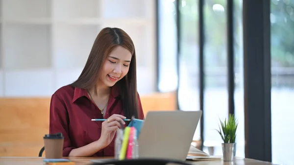 Foto Joven Hermosa Diseñadora Camisa Roja Tomando Notas Frente Portátil — Foto de Stock