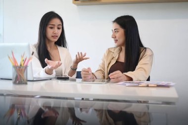 Genç bayan, yaratıcı ofisindeki meslektaşına yeni bir fikri açıklıyor..