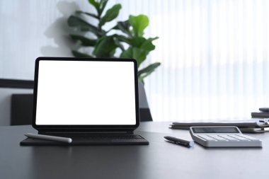 Boş ekran ile bilgisayar tabletinin görünümünü kapat, hesap makinesi modern karanlık ofis masasında.