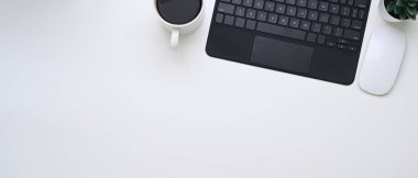 Kablosuz klavye, kahve fincanı, bitki ve fotokopi alanının beyaz arkaplanda asgari çalışma alanının yatay fotoğrafı.